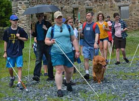 A group of blind students and mentors walk outside together.